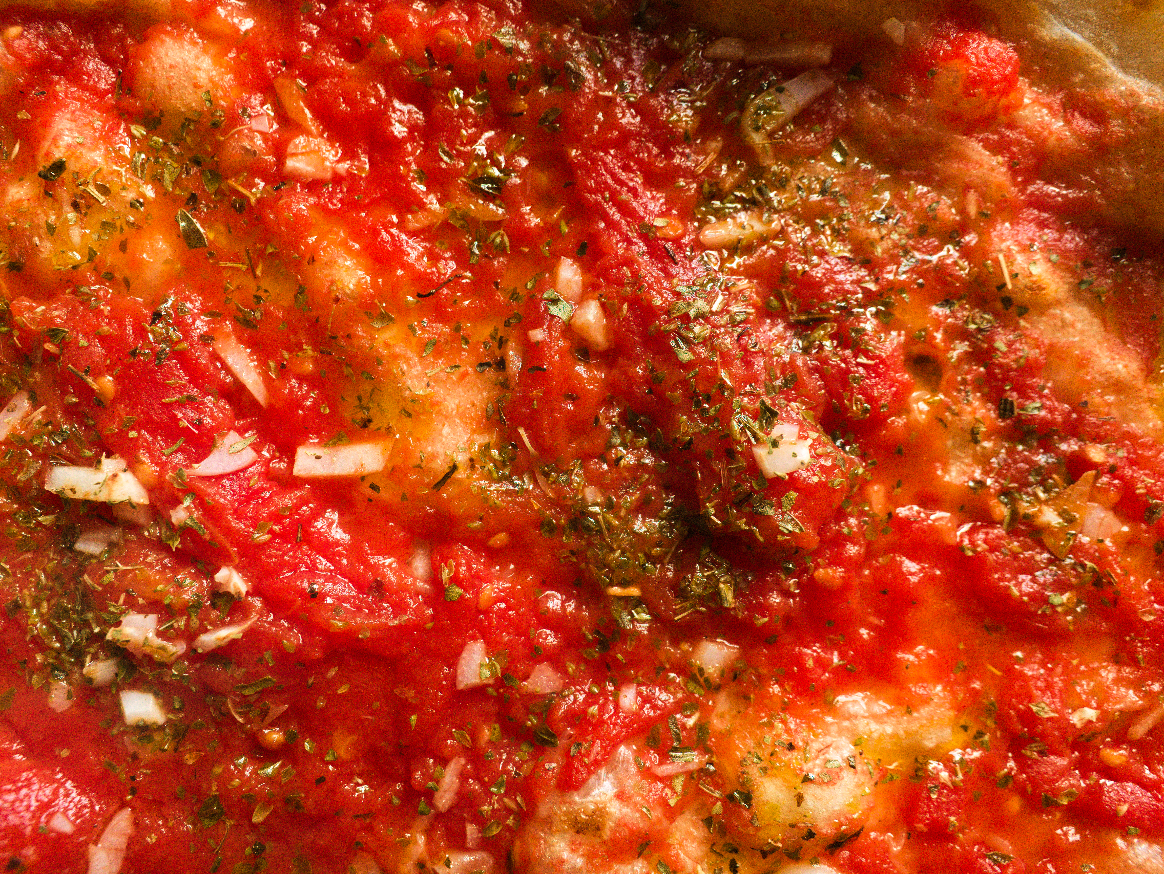 die vegane, geschmacksintensive Pizza Marinara ist die Urform der neapolitanischen Pizza. Saftige Tomatensoße ist zu sehen.